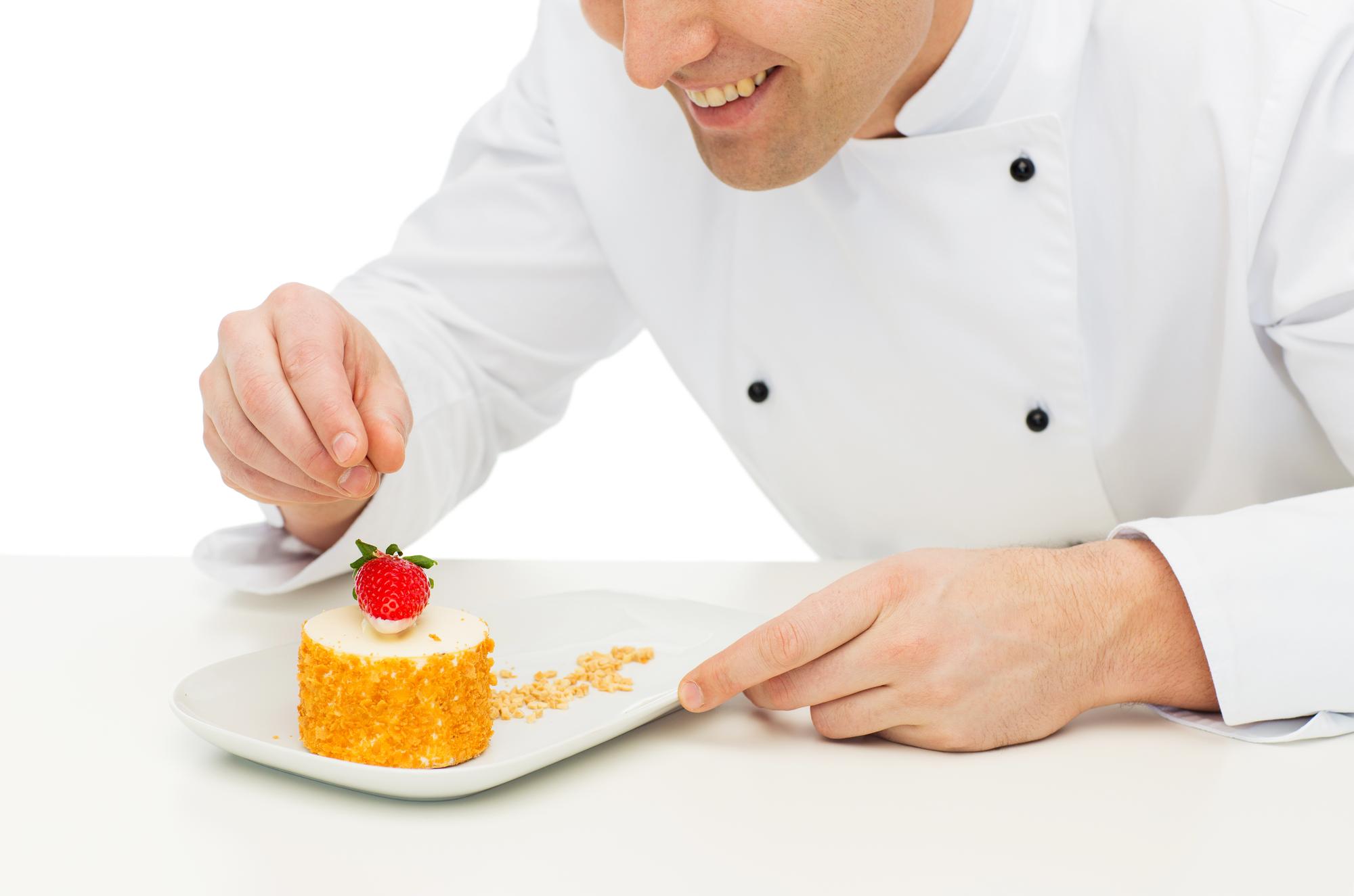 Student plating dessert under instructor guidance