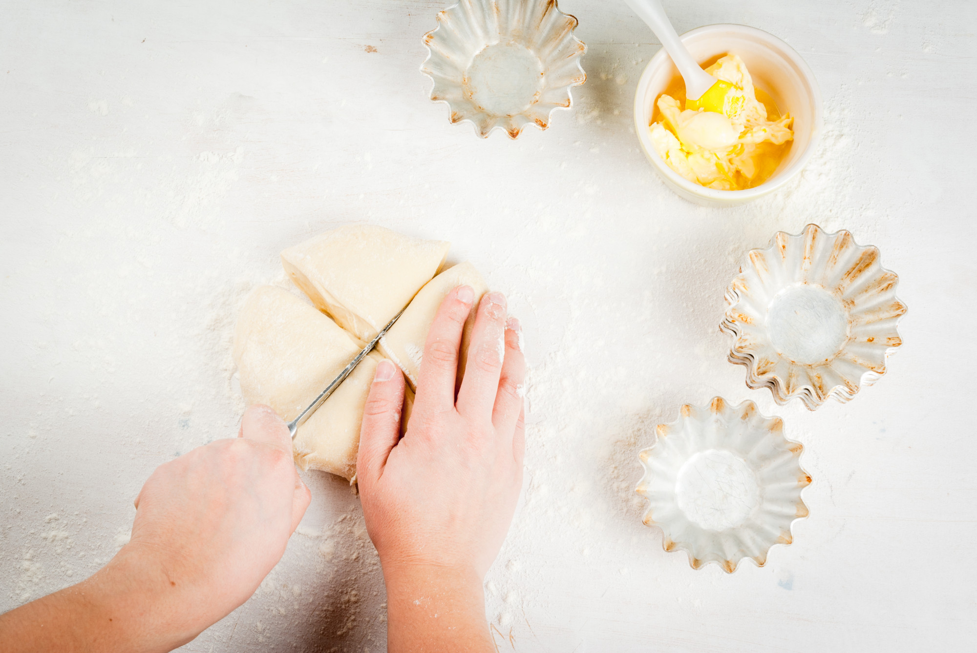 Hands folding pastry in warm light